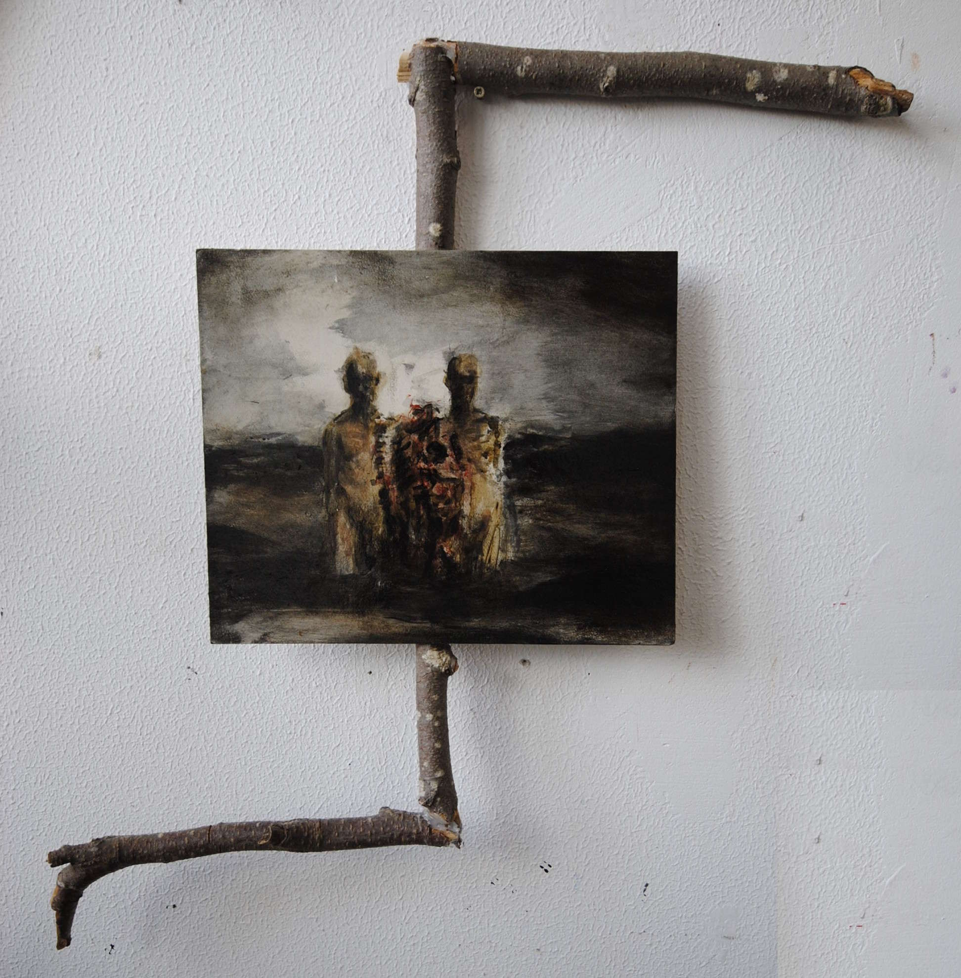Donker figuratief werk gemonteerd in een frame van takken